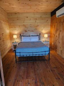 a bedroom with a bed in a log cabin at Horse Farm Retreat in Sherburne