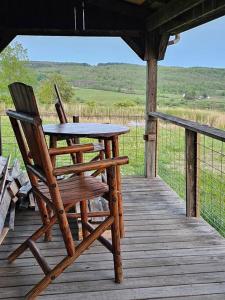 a table and chairs sitting on a wooden porch at Horse Farm Retreat in Sherburne
