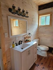 a bathroom with a white sink and a toilet at Horse Farm Retreat in Sherburne
