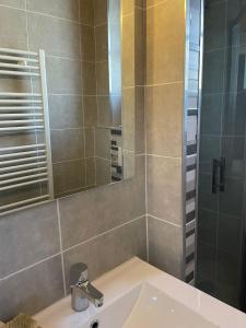 a bathroom with a sink and a shower with a mirror at Appartement Cosy idéalement situé in Le Grand-Bornand