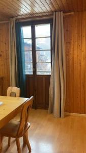 a dining room with a table and a large window at Appartement Cosy idéalement situé in Le Grand-Bornand