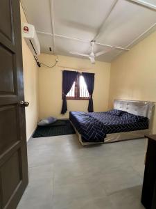 een kamer met 2 bedden en een raam bij HOMESTAY WARISAN BENTONG in Bentong