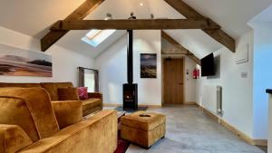 a living room with a couch and a fireplace at Charming Countryside Barn in Pencader