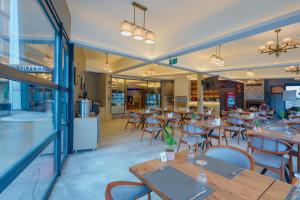 un restaurant avec des tables et des chaises en bois et une cafétéria dans l'établissement Silver Inn Spa, à Kasaplar