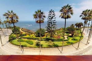 a park with palm trees in front of the ocean at Bellísimo departamento de estreno en Barranco in Lima