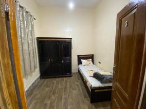 um pequeno quarto com uma cama e um armário em Private room in the kasbah em Tânger