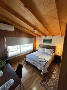 a bedroom with a bed and a window at Hostal Senderos del Sur in Freire