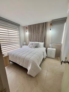 ein Schlafzimmer mit einem großen Bett und einem Fenster in der Unterkunft Lindo y cómodo apartamento 804 in Cali