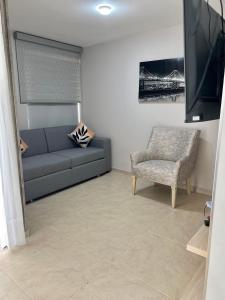 ein Wohnzimmer mit einer Couch und einem Sessel in der Unterkunft Lindo y cómodo apartamento 804 in Cali