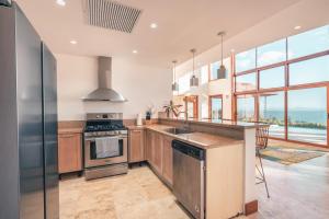 a kitchen with stainless steel appliances and a large window at Luxe retreat at Puerto Bahia Bkfst included in Santa Bárbara de Samaná