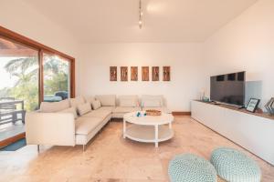 a living room with a couch and a tv at Luxe retreat at Puerto Bahia Bkfst included in Santa Bárbara de Samaná