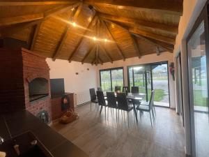 a dining room with a table and chairs and a fireplace at Casa cu Tihna in Fundu Moldovei