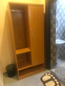a bathroom with a shower with a wooden cabinet at Dopad Hills Hotel and Suites in Ojo