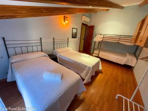 una habitación con tres camas en una habitación en Casa Rural El Junquillo, en Cuevas de San Marcos 36 fotos más