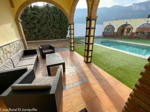 un patio con sofá y piscina en Casa Rural El Junquillo en Cuevas de San Marcos