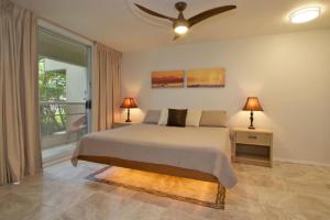NEW Luxury Condo at Kameole Beach في ويليا: غرفة نوم بسرير ومروحة سقف