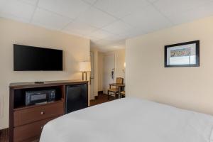 um quarto de hotel com uma cama e uma televisão de ecrã plano em Quality Inn Ocean City Beachfront em Ocean City