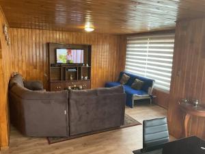 sala de estar con sofá y TV en Casa vista canal Dalcahue, en Dalcahue