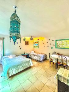 a bedroom with two beds and a table and a chandelier at Casa Ecológica in Tepoztlán