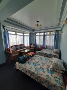 - une chambre avec deux lits et un canapé dans l'établissement ShivaPuri Homestay, à Darjeeling