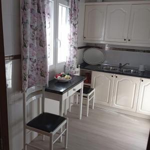 eine Küche mit einem Tisch und einer Obstschale darauf in der Unterkunft Casa La Loma en Archidona in Málaga