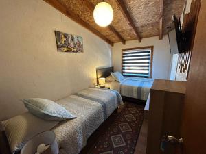 a room with two beds and a window in it at Hostal Senderos del Sur in Freire