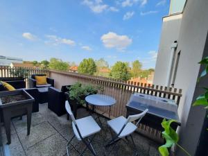 a patio with a table and chairs on a balcony at Magnifique appartement avec terrasse et parking, 8 Personnes in Nanterre