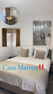 1 Schlafzimmer mit einem großen weißen Bett und einem Badezimmer in der Unterkunft Casa Matteo in Moisei