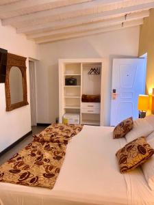 a bedroom with a large bed and a refrigerator at Hotel Aromax del Campestre in Medellín