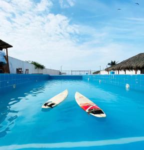 dos tablas de surf en el agua en una piscina en Zorritos Backpakers, en Tumbes