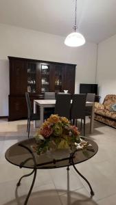 una sala de estar con una mesa con flores. en Corona Apartments en Terralba