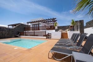 een villa met een zwembad en ligstoelen bij Casa Familia in Playa Blanca