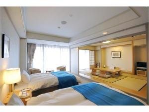 Habitación de hotel con 2 camas y mesa en Hotel Alegria Gardens Amakusa - Vacation STAY 40451v en Amakusamachi