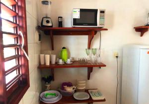 a kitchen with wooden shelves and a microwave at Apê Namastê in Natal