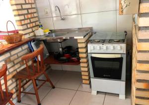 una pequeña cocina con fogones y fregadero en Apê Namastê, en Natal