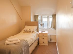 een kleine slaapkamer met een bed en een raam bij Foxley Cottage in Charmouth