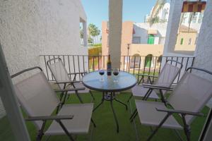 a patio with a table and chairs on a balcony at Sunstay PRIMERA LINEA DE PLAYA! Aptos Rio Marina in Nerja