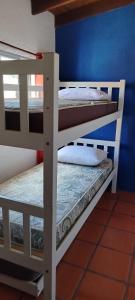 two bunk beds in a room with a blue wall at Alas del Mar in Punta Del Diablo