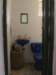 a bathroom with a blue toilet and a sink at Allegra in Gómez Plata