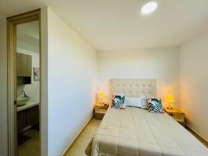 a bedroom with a large bed with two pillows on it at Stunning view, near airport JMC, fast Wi-Fi in Marinilla