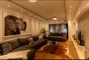 uma sala de estar com um sofá e uma fotografia de elefante em Downtown Oasis Unirii Apartment em Bucareste