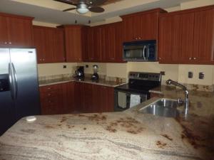 cocina con encimera sucia y nevera en 3 Bedroom Condo with Ocean View - Tres Regalos 201N, en Jacó