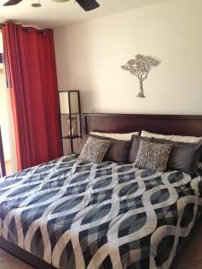 1 dormitorio con 1 cama grande y un árbol en la pared en 3 Bedroom Condo with Ocean View - Tres Regalos 201N, en Jacó