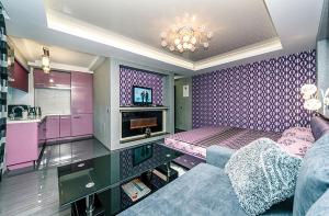 een paarse woonkamer met een bank en een tv bij Hotrent Bessarabka Arena in Kiev