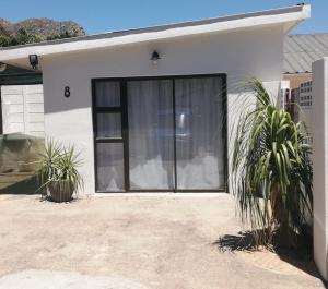 eine Garagentür eines Hauses mit zwei Pflanzen in der Unterkunft Montagu Meander is a cozy flat for work and play with Wi-Fi and secure parking in Montagu