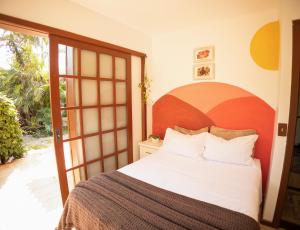 een slaapkamer met een groot bed en een glazen schuifdeur bij Casa Örüm in Florianópolis