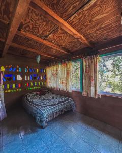 a bedroom with a bed in a room with windows at Casa Ecológica in Tepoztlán