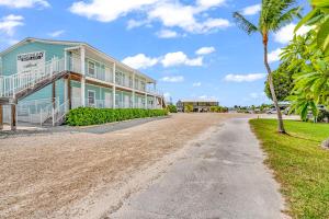 a house with a palm tree and a dirt road at Bonefish Bay Motel in Marathon