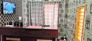 a room with a desk with a window and a curtain at Diamond Lodge in Shimoga