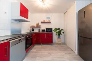 a kitchen with red cabinets and a refrigerator at Appartement cosy au centre ville de Menton in Menton